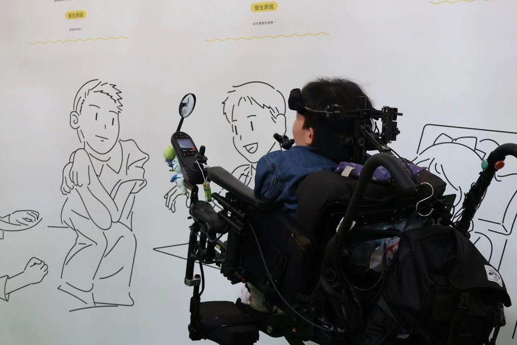 維維在展場看著牆上畫著自己的插畫
